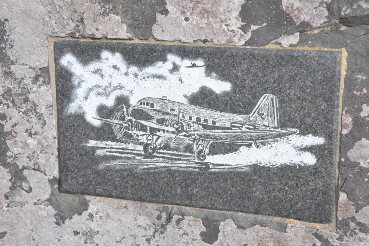 Close-up of a memorial stone at Saltby, with an engraving of an American C-47 troop-carrying aircraft