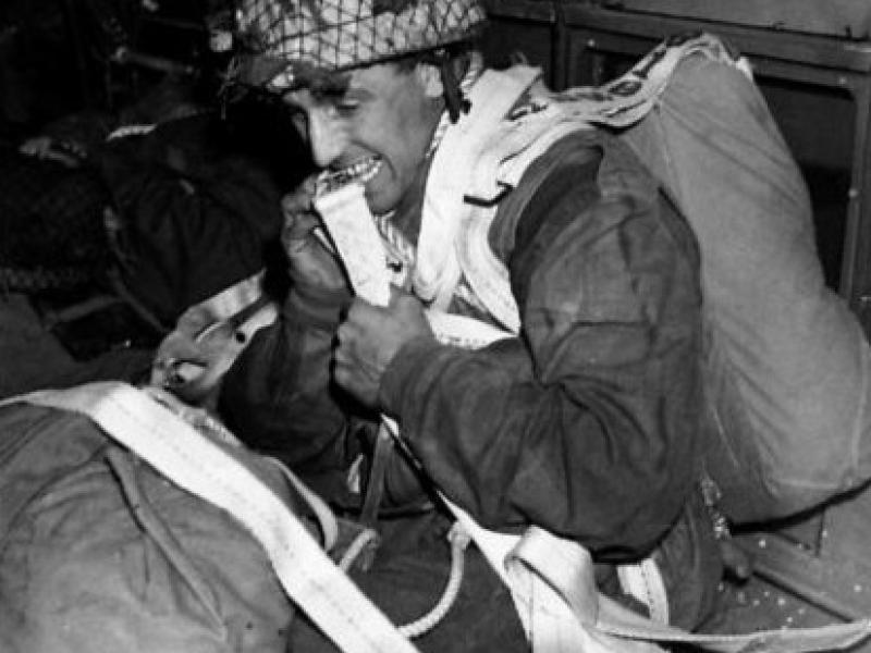 A paratrooper prepares to stand up and jump from a C-47 aircraft