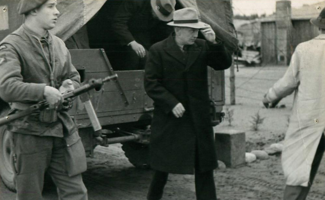A paratrooper watches over arrested Gestapo men.