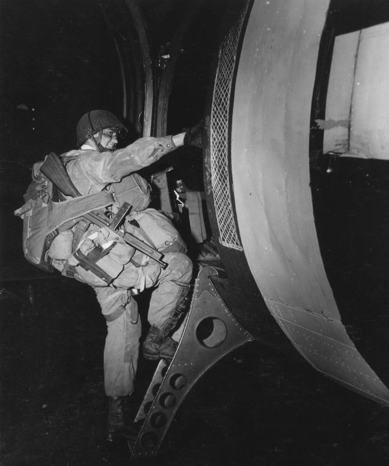 A US paratrooper climbs on board a C-47 aircraft