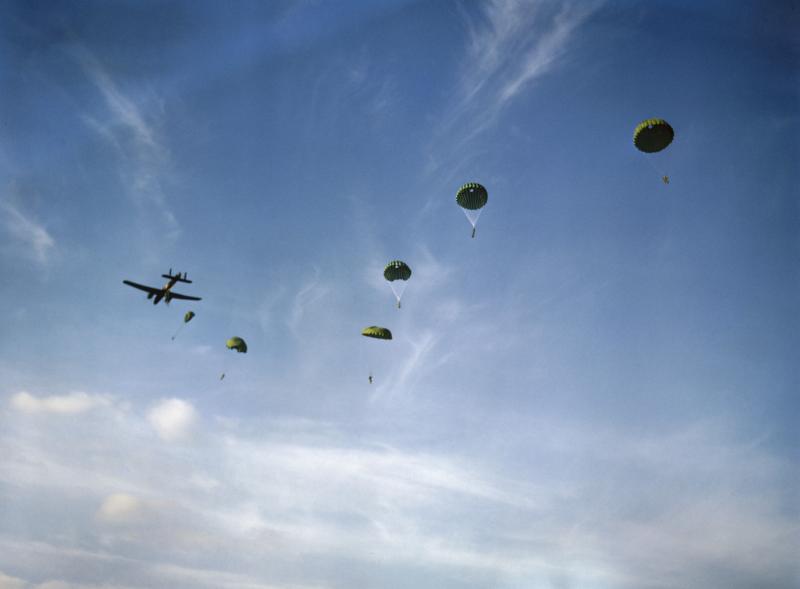 Paratroopers descend from an RAF Whitley aircraft