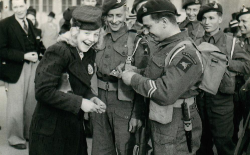 A member of the 2nd Battalion, South Staffordshire Regiment, happily gives his autograph to a young Norwegian lady.