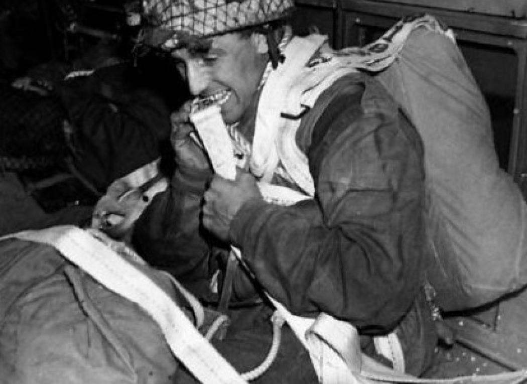 A paratrooper prepares to stand up and jump from a C-47 aircraft